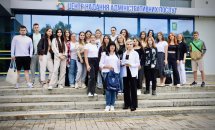 Група людей стоять на сходах перед будівлею.
