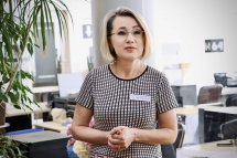 Жінка з бейджем проводить презентацію чи виступ.