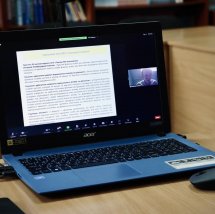 Ноутбук із відкритим документом та відеоконференцією в кутку екрана.