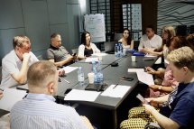 Група людей працює за столами у сучасному офісі.