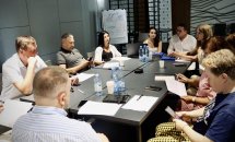 Група людей працює за столами у сучасному офісі.