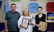 Жінки з грамотами та нагородами на фоні кольорової стіни.