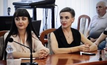 Дві жінки сидять за столом.