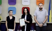 Дві жінки з грамотами та чоловік позують для фото.