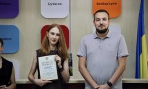 Жінка з нагородою та чоловік.