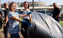 Дівчина тримає великий мішок для сміття під час прибирання.