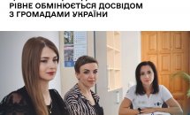 Три жінки сидять за столом, уважно слухають.