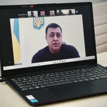 Онлайн-зустріч, чоловік на екрані ноутбука говорить.