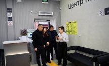 Люди йдуть коридором установи, рухаючись до іншого приміщення.