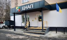 Будівля ЦНАП із прапорами України перед входом.