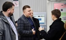 Двоє чоловіків та жінка спілкуються у робочій зоні.