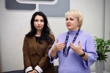 Дві жінки обговорюють питання у просторому офісі.