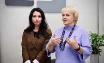 Дві жінки обговорюють питання у просторому офісі.