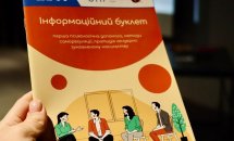 Людина тримає у руках буклет із заголовком "Інформаційний буклет".