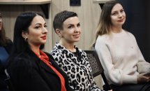  Три жінки сидять у приміщенні та посміхаються