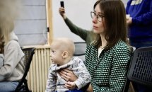Жінка в окулярах тримає дитину.