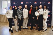 Групове фото людей у білій та чорній формі на фоні банера «Save a Life».