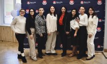 Групове фото людей у білій та чорній формі на фоні банера «Save a Life».