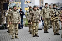 Військовослужбовці у формі маршем проходять по площі.