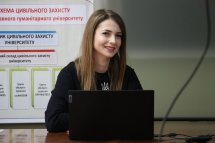 Молода жінка з ноутбуком веде лекцію.