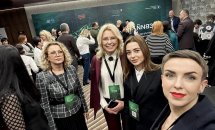 Групове селфі чотирьох жінок у конференц-зоні, вони усміхаються.