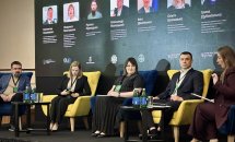 Панельна дискусія з кількома спікерами, велика аудиторія в конференц-залі.