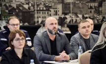 Ділова зустріч: Четверо людей сидять за столом, обговорюючи питання на тлі міського пейзажу.