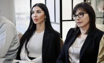 Три жінки на конференції: Жінки у ділових костюмах уважно слухають виступ.