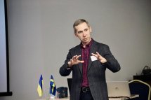 Чоловік у костюмі проголошує доповідь