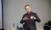 Чоловік у костюмі проголошує доповідь