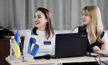 Дві жінки перебувають в офісі. Вони посміхаються