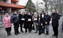 Група людей, які стоять біля будівлі, на вулиці.