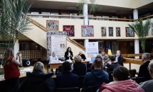 Люди у приміщення, на задньому плані картини