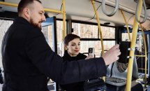 У тролейбусі чоловік та жінка, яка тримає телефон