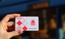 Картка для оплати проїзду, біла з червоними елементами та гербом Рівного, тримається в руці.