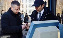 Двоє чоловіків стоять на вулиці та обговорюють щось. На передньому фоні стоїть термінал. 