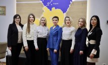Жінки стоять у кабінеті та посміхаються. На задньому фоні видно карту Рівненської області.