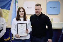Чоловік та жінка, яка тримає у руках почесну грамоту.