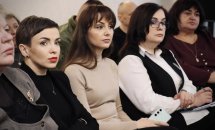 Жінки сидять у залі та беруть участи у діалоговій зустрічі