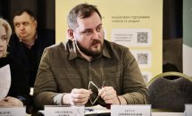 Чоловік та жінка сидять за столом. Вони беруть участь у діалоговій зустрічі.