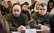 Чоловіки у війcьковій формі беруть участь у діалоговій зустрічі. 