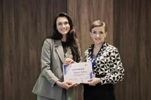 Двоє жінок посміхаються та тримають в руках сертифікат.