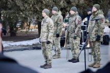 Чотири військовослужбовці стоять на дворі.