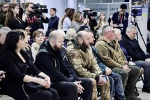 Люди сидять в приміщенні ЦНАПу і слухають доповідь.