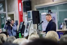 Чоловік у костюмі проголошує доповідь.