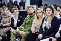 Люди сидять в приміщенні ЦНАПу і слухають доповідь.