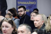 Люди сидять в приміщенні ЦНАПу і слухають доповідь.
