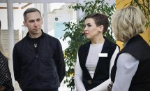 Дві жінки та чоловік стоять у приміщення на фоні зелених рослин