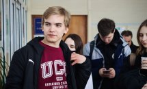 Хлопець перебуває у приміщенні. На фоні інші люди.