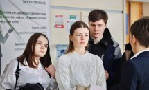 Двоє дівчат та хлопець перебувають у приміщенні.